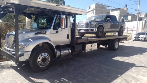 Servicio de grúa plataforma (International) transportando equipo pesado en CDMX y Estado de México — foto 1